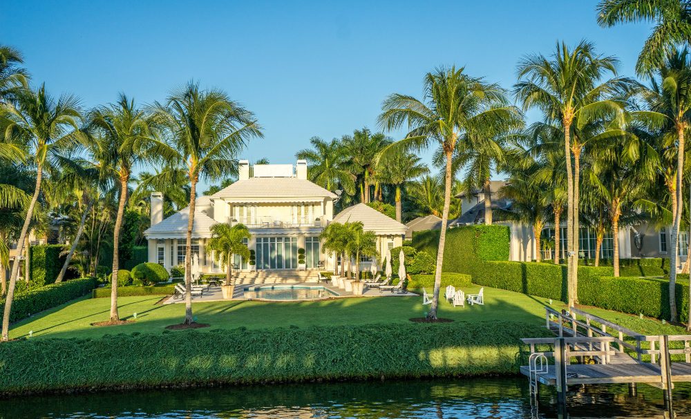 An image of a mansion with a tropical garden design. 