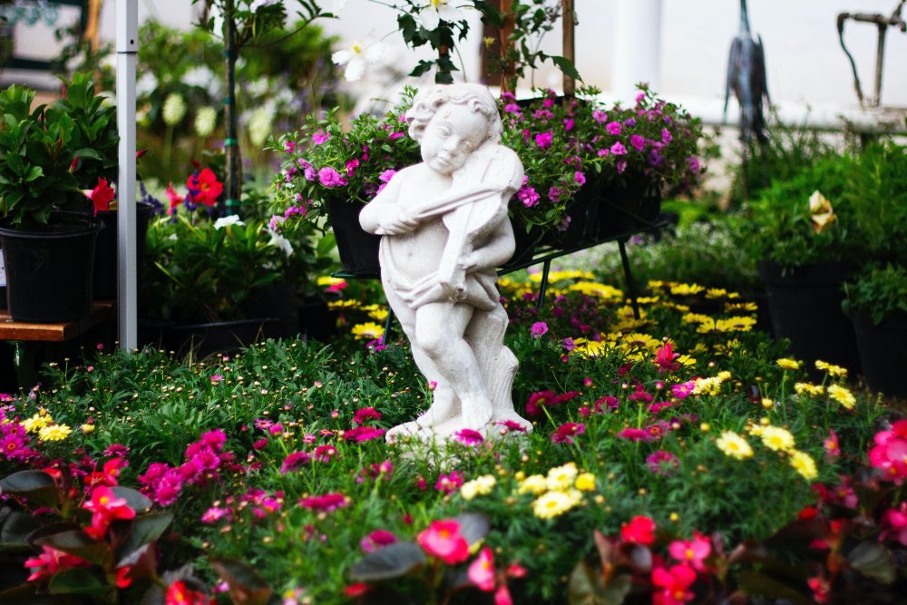 an image of a flower garden with a statue feature.